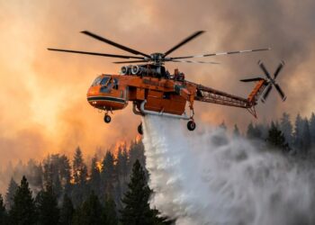 Helicóptero S-64 despeja água sobre incêndio florestal