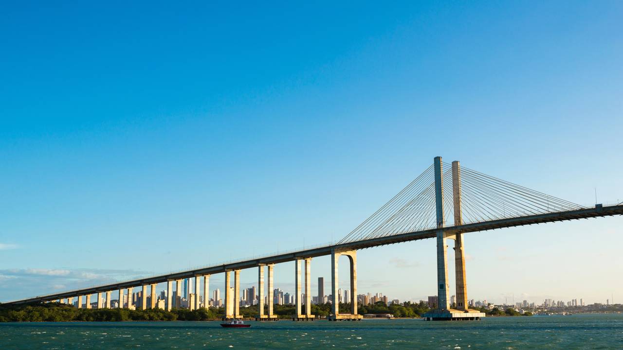 A monumental estrutura estaiada de 1,78 km de extensão com mastros de 103 metros de altura que se eleva sobre o rio Potengi para ligar as praias da zona norte