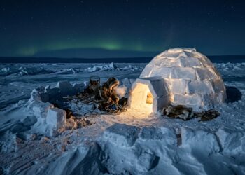 A física termodinâmica demonstra que os abrigos erguidos há 4.000 anos com a técnica inuit de blocos de gelo espiralados não se tornam frigoríficos mortais: eles desenvolvem silenciosamente algo que a maioria dos isolamentos sintéticos nunca conseguirá oferecer, a capacidade estrutural de capturar o calor do próprio corpo humano para manter a casa 40 graus mais quente que a tempestade lá fora, sem precisar de eletricidade
