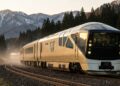 Trem futurista japonês Shiki-Shima dourado cruzando montanhas ao entardecer