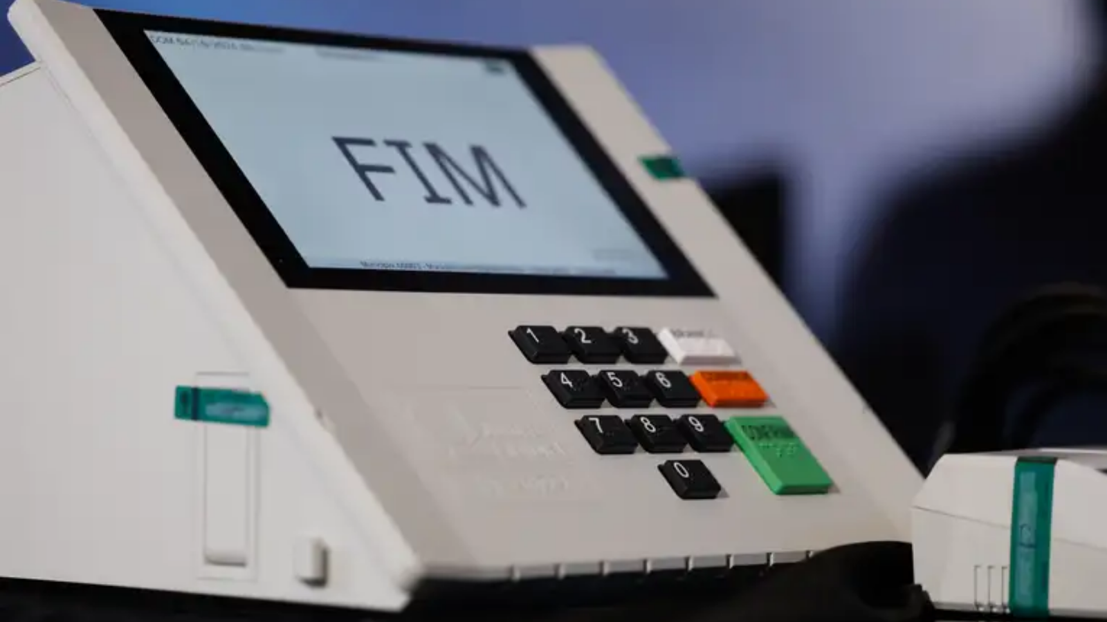 Urna eletrônica em primeiro plano com a palavra "fim" em destaque.