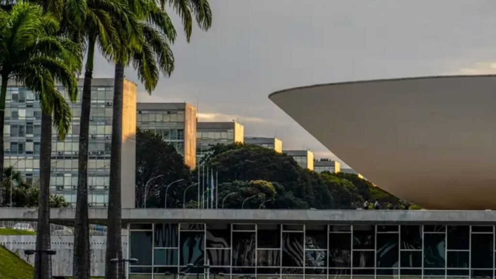Fachada do Congresso Nacional, em Brasília, com uma das cúpulas do complexo arquitetônico em destaque e prédios administrativos ao fundo.