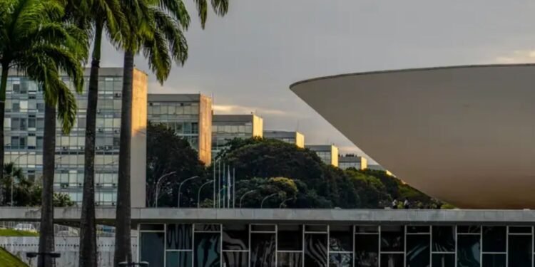 Fachada do Congresso Nacional, em Brasília, com uma das cúpulas do complexo arquitetônico em destaque e prédios administrativos ao fundo.
