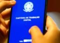 Aplicativo da Carteira de Trabalho Digital aberto no celular enquanto uma pessoa segura o aparelho com as mãos.