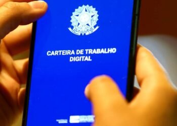 Aplicativo da Carteira de Trabalho Digital aberto no celular enquanto uma pessoa segura o aparelho com as mãos.