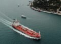 Navio vermelho passando no Estreito de Ormuz.