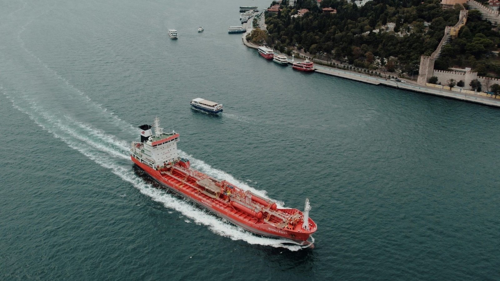Navio vermelho passando no Estreito de Ormuz.