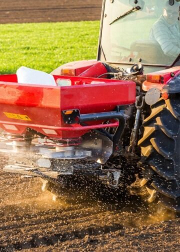 Máquina agrícola jogando fertilizante na plantação.