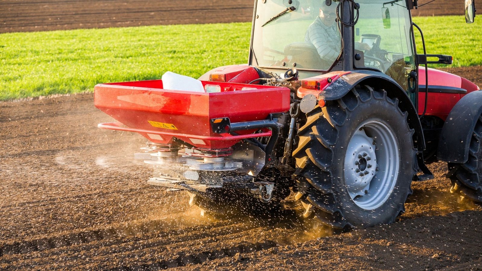 Máquina agrícola jogando fertilizante na plantação.