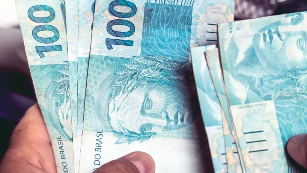 Notas de R$ 100 reiais nas mãos de uma pessoa.