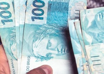Notas de R$ 100 reiais nas mãos de uma pessoa.