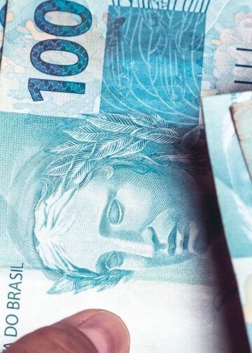 Notas de R$ 100 reiais nas mãos de uma pessoa.