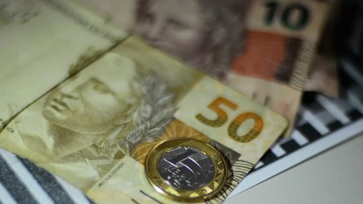 Notas de dinheiro e moeda de 1 Real.